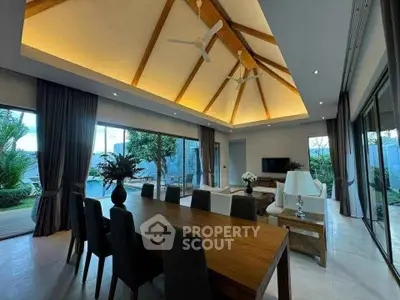Luxurious open-plan living room with high ceilings and elegant dining area, offering stunning garden views.