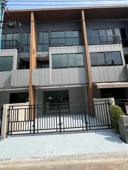 Modern townhouse exterior with sleek design and gated entrance