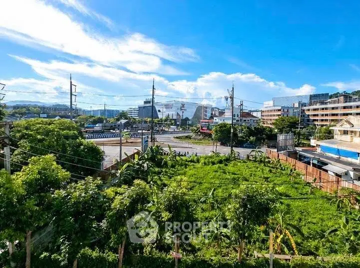 Scenic view of lush greenery and urban landscape under a bright blue sky, perfect for real estate development.