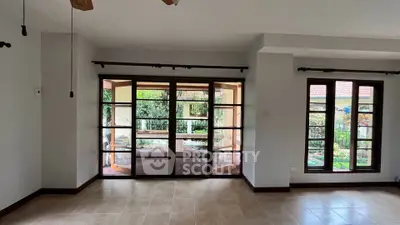 Spacious living room with large windows offering garden views in a modern home.