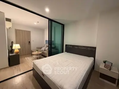 Modern bedroom with glass partition and cozy living area in stylish apartment