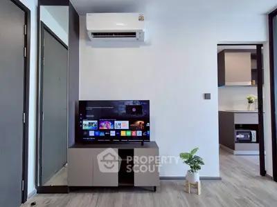 Modern living room with sleek TV setup and air conditioning unit.