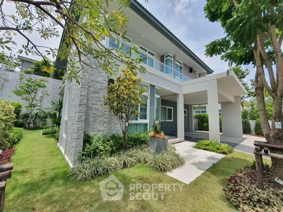 Modern two-story house with lush garden and stone facade, perfect for family living.