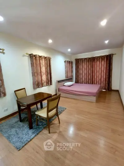 Spacious studio apartment with wooden flooring and cozy dining area