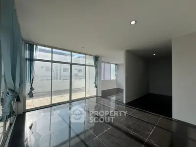 Spacious modern living room with large windows and sleek black flooring