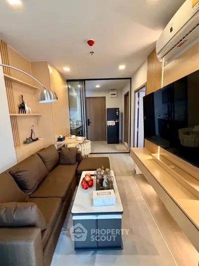 Modern living room with sleek design, featuring a cozy sofa, stylish decor, and a large flat-screen TV.