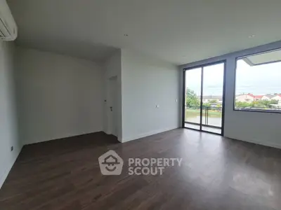 Spacious modern living room with large windows and wooden flooring