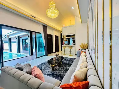 Luxurious living room with elegant chandelier and pool view