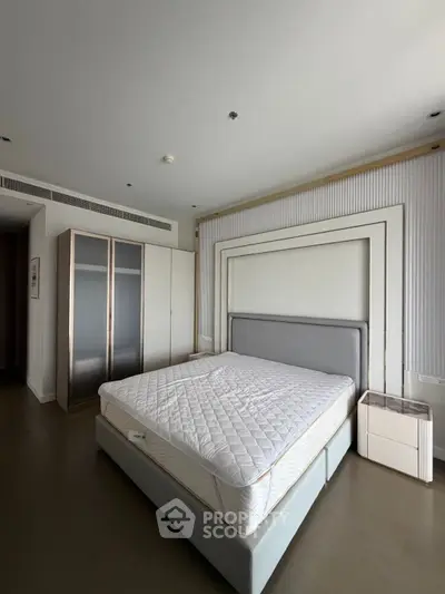 Spacious modern bedroom with elegant design and ample natural light, featuring a large bed and sleek wardrobe.