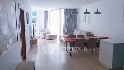 Spacious modern living room with dining area and large windows offering natural light.