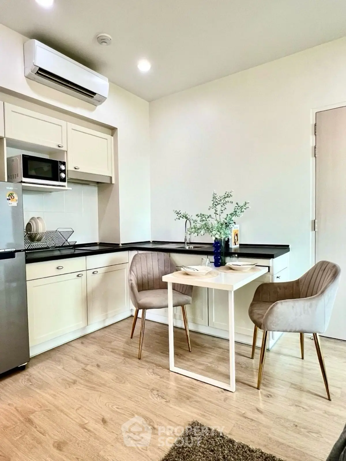 Modern kitchen with sleek design, featuring compact dining area and stylish chairs.