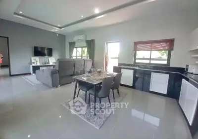 Spacious modern living room with open kitchen and elegant dining area, perfect for entertaining.