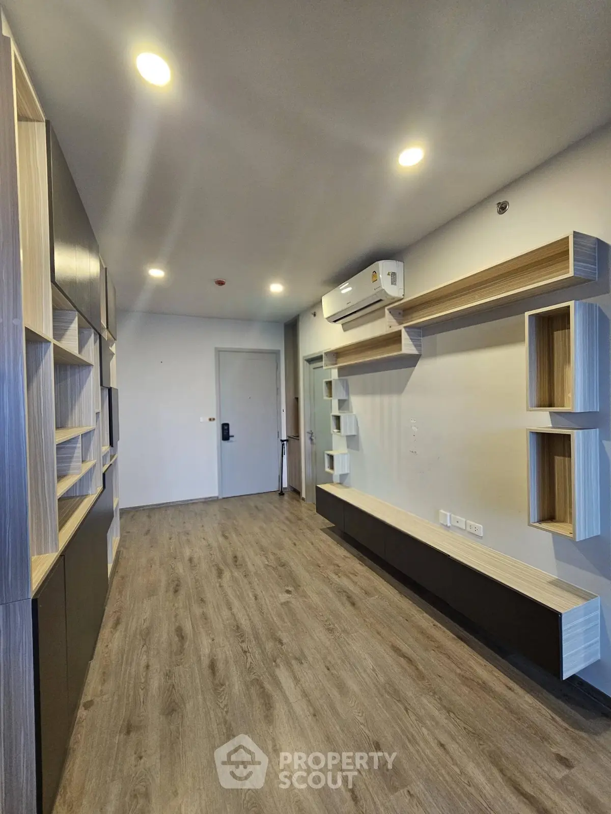 Modern living room with stylish built-in shelves and wood flooring