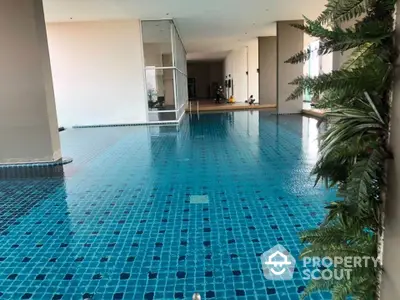 Luxurious indoor swimming pool with modern design and lush greenery, perfect for relaxation and leisure.