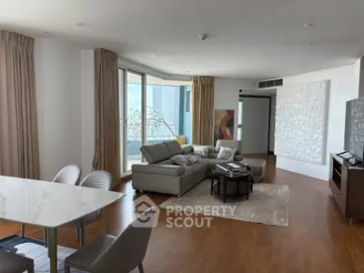 Spacious modern living room with elegant decor and large windows offering natural light.