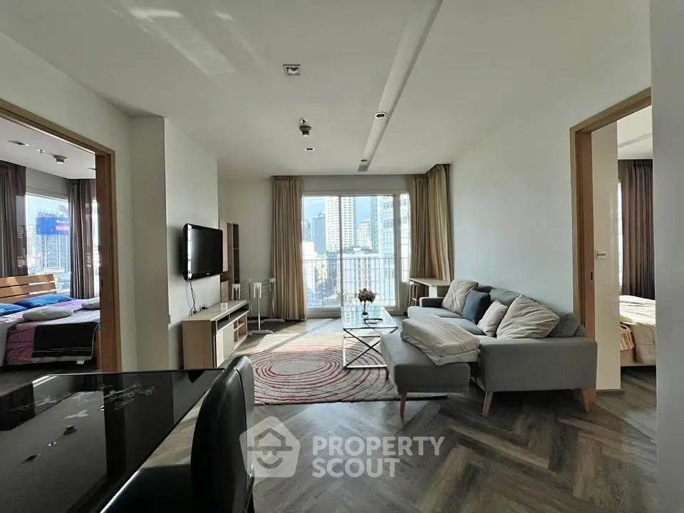 Spacious modern living room with city view, featuring stylish furniture and natural light.