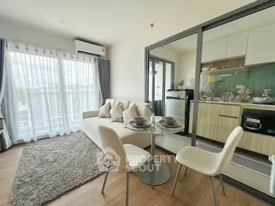 Modern open-plan living room with kitchen, featuring stylish decor and natural light.