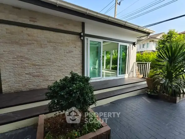 Charming home exterior with sliding glass doors and lush greenery