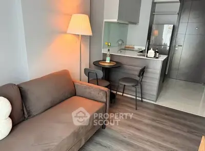 Cozy modern living room with stylish furniture and compact kitchen area.