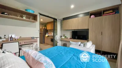 Spacious bedroom with modern wooden cabinetry and ample storage, featuring a cozy bed and integrated entertainment unit, perfect for relaxation.