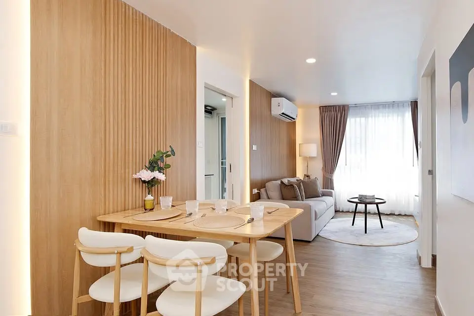 Modern living room with elegant dining area and cozy seating, featuring stylish decor and natural light.