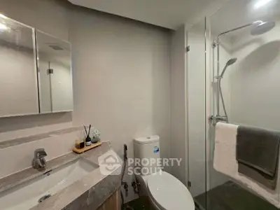 Modern bathroom with sleek shower and elegant vanity in a contemporary home.
