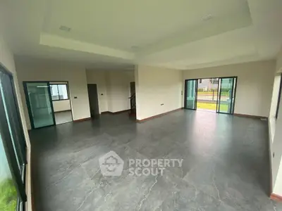 Spacious modern living room with large windows and sleek flooring