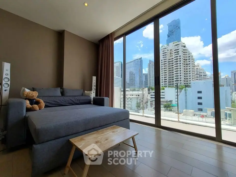 Modern living room with large windows offering stunning city views in a high-rise apartment.