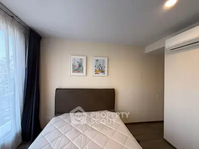 Cozy bedroom with modern decor and natural light, featuring a comfortable bed and stylish wall art.