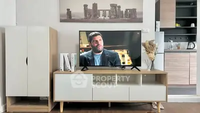 Modern living room with stylish TV stand and open kitchen layout