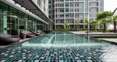 Luxurious apartment complex with modern pool and stylish outdoor seating area.