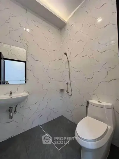 Modern bathroom with sleek design featuring a wall-mounted sink and toilet.