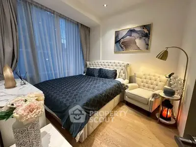 Luxurious bedroom with elegant decor and plush furnishings, featuring a cozy armchair and ambient lighting.