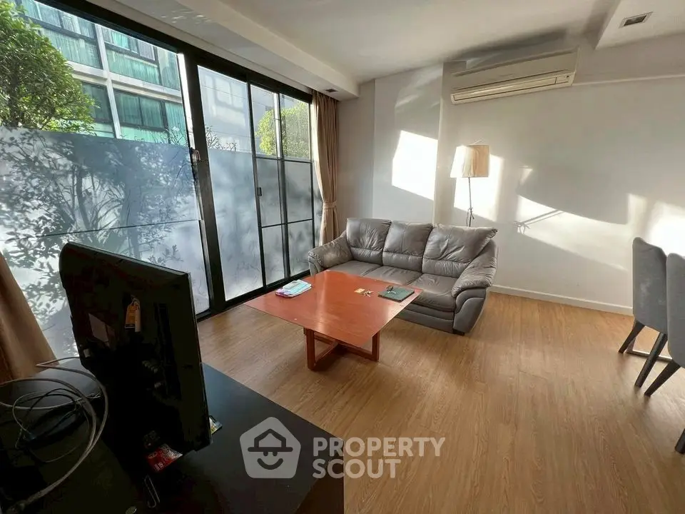 Spacious living room with modern sofa and large windows for natural light.