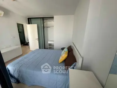 Spacious bedroom with modern design and ample natural light, featuring a comfortable bed and built-in closet.