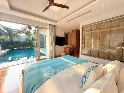 Luxurious bedroom with pool view, modern decor, and ample natural light in a tropical setting.