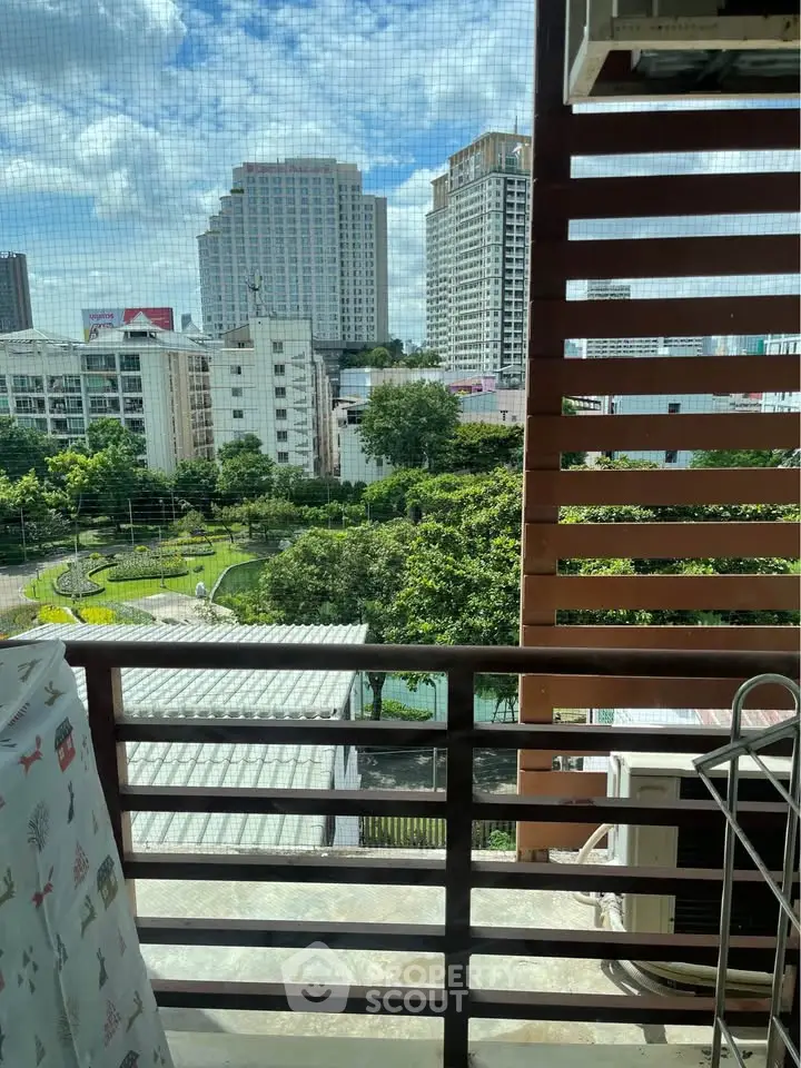 Urban balcony view with cityscape and greenery, perfect for relaxation and enjoying the skyline.
