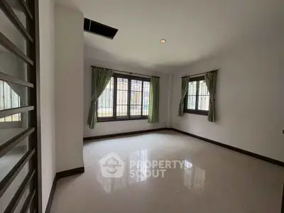 Spacious empty room with large windows and tiled floor, perfect for customization.