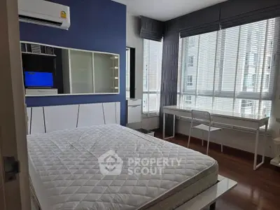 Modern bedroom with large windows and stylish decor in a high-rise apartment.