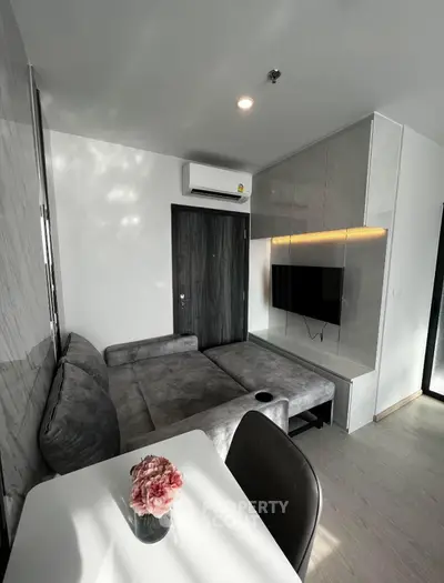 Modern living room with sleek furniture and wall-mounted TV in a stylish apartment.