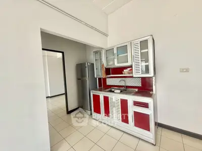 Modern kitchen with red and white cabinets and stainless steel fridge
