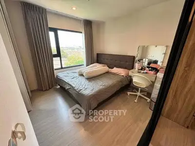 Cozy bedroom with large window and modern furnishings, perfect for relaxation and comfort.
