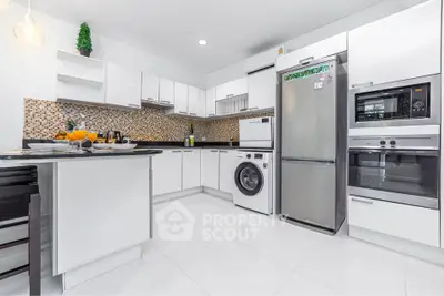 Modern kitchen with sleek white cabinets, stainless steel appliances, and mosaic backsplash.