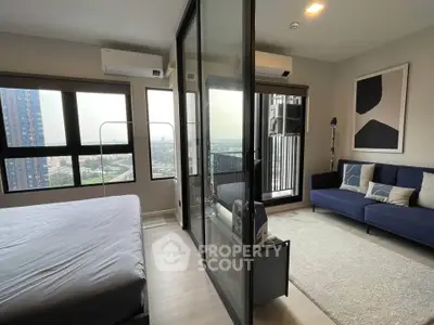 Modern bedroom with glass partition and city view, featuring a cozy living area and stylish decor.