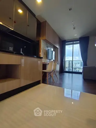 Modern open-layout kitchen and living room with city view, featuring sleek cabinetry and contemporary furnishings.