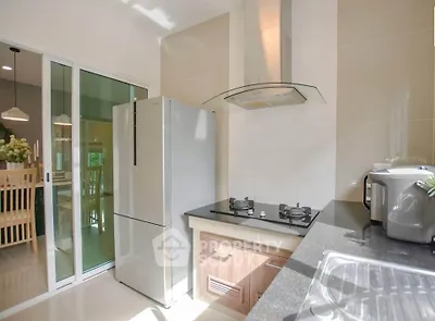 Modern kitchen with sleek appliances and open layout, featuring a gas stove and spacious dining area.