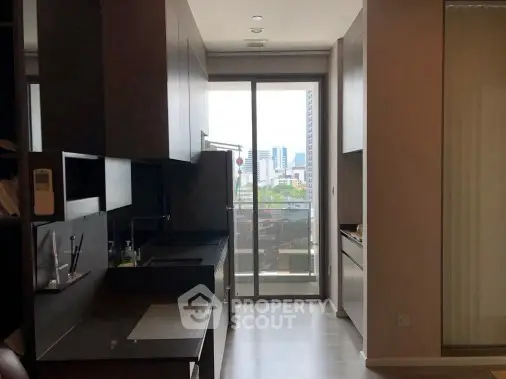 Modern kitchen with sleek cabinetry and city view from balcony.