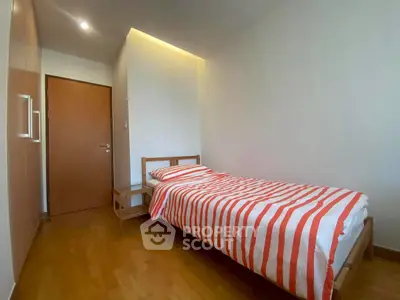 Cozy bedroom with single bed and striped bedding in modern apartment