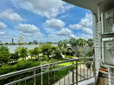 Stunning balcony view overlooking lush greenery and river, perfect for relaxation and enjoying nature.