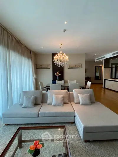 Luxurious living room with elegant chandelier and modern furniture in a spacious open layout.